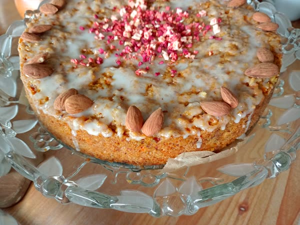 Mandelkuchen mit Zuckerguss und gefriergetrockneten Beeren auf Glas-Etagere